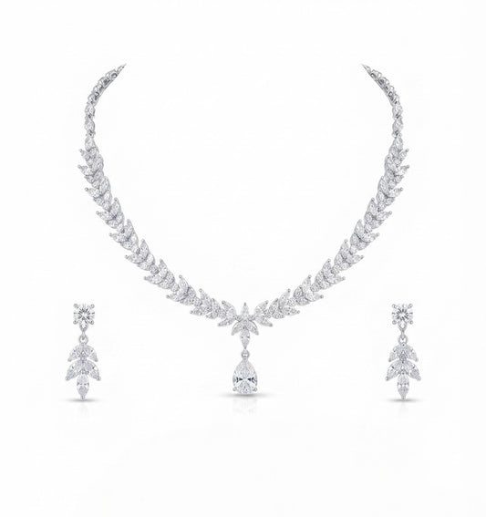 A white gold or platinum jewelry set featuring a leaf-patterned necklace with a teardrop pendant and matching drop earrings, displayed on a clean white background.