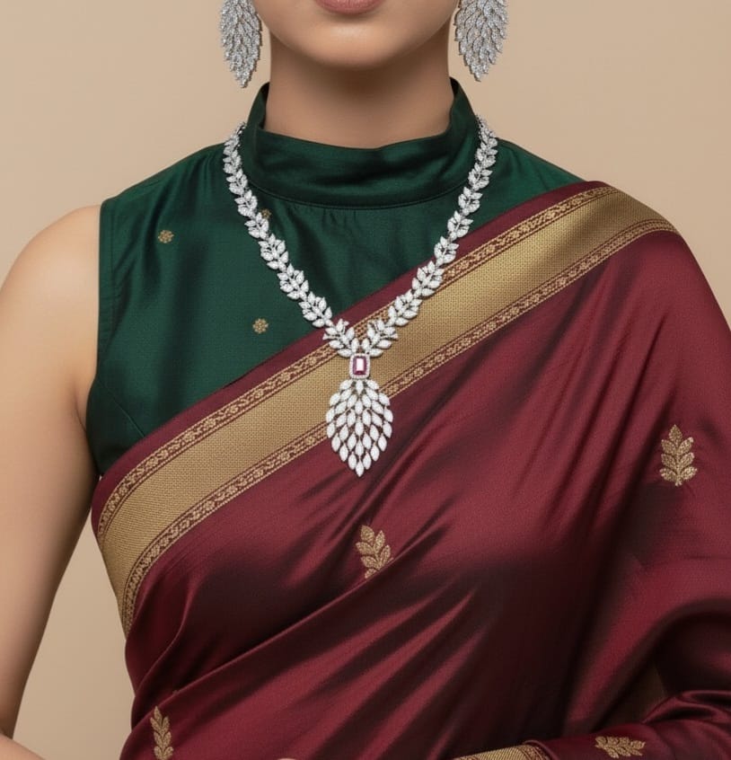 Woman wearing a green and maroon saree with a diamond necklace on a beige background