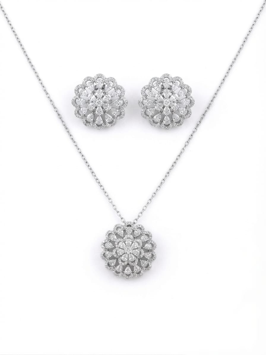 Silver-tone jewelry set featuring a necklace and matching stud earrings, each with a round floral cluster design set with clear stones on a white background.