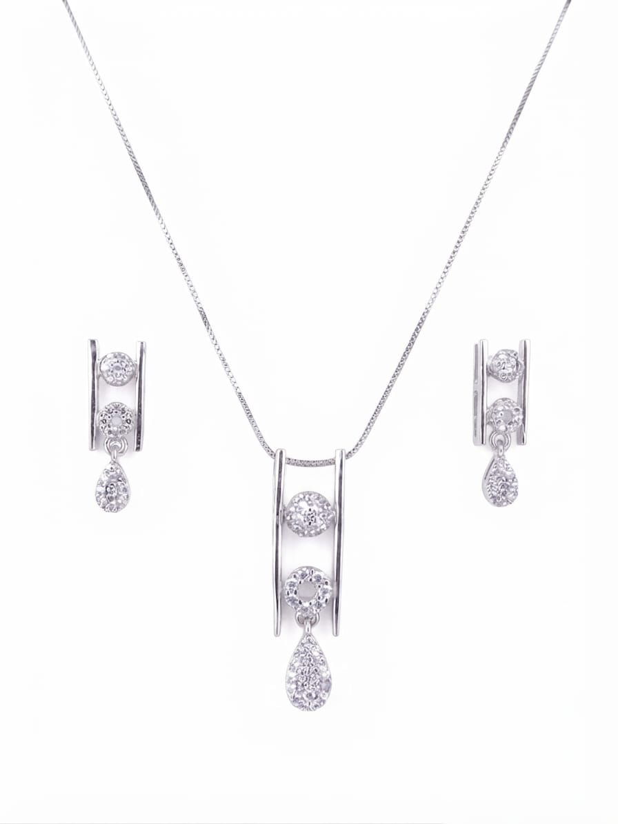 Silver-tone jewelry set featuring a necklace with a double-bar pendant and matching drop earrings, each adorned with clear gemstones, on a plain white background.