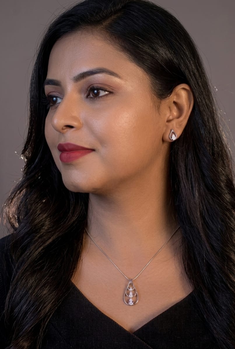Woman wearing a necklace with a pendant against a neutral background