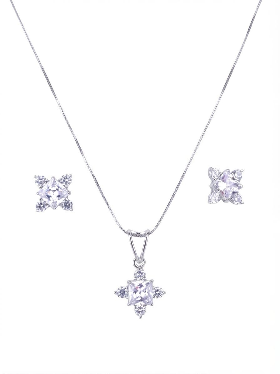 Silver-tone jewelry set featuring a delicate chain necklace with a starburst pendant, matching stud earrings, and clear gemstones on a plain white background.