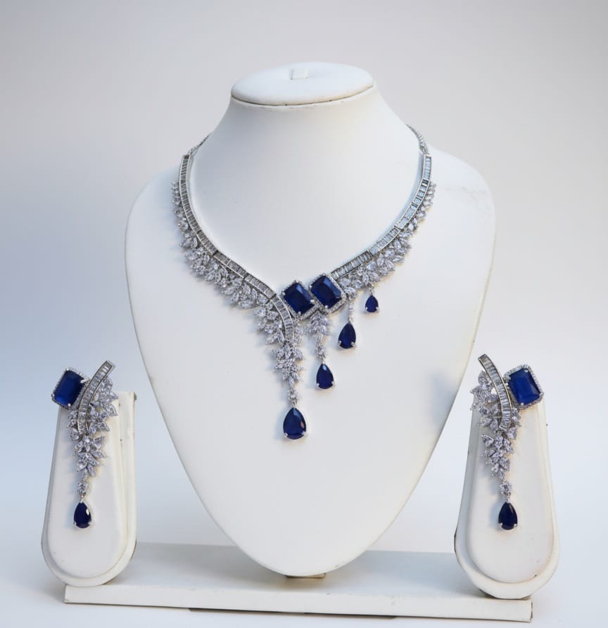 Jewelry set with necklace and earrings on a white stand